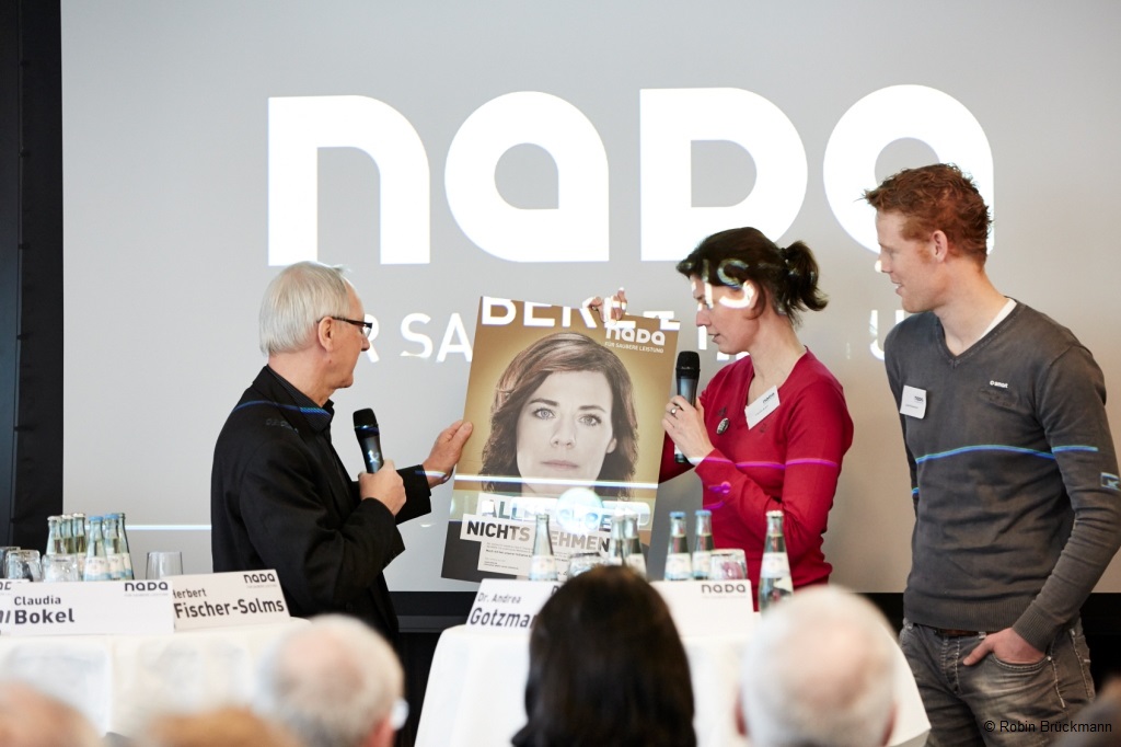 Moderator presents Claudia Bokel with a picture of her, Jonas Reckermann is standing next to her.