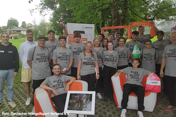 Gruppe von Minigolf-Spielern*innen trägt graues Shirt mit Initiativ-Claim