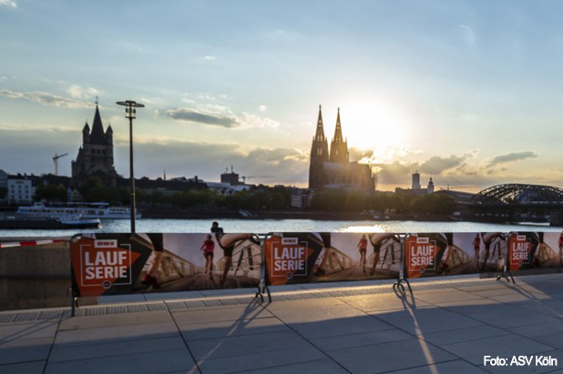 View of Cologne Cathedral with banner for the OBI running series in the foreground