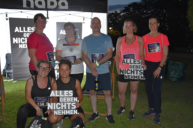 Läufer und Läuferinnnen mit Statement-Schildern bei Bonner Nachlauf