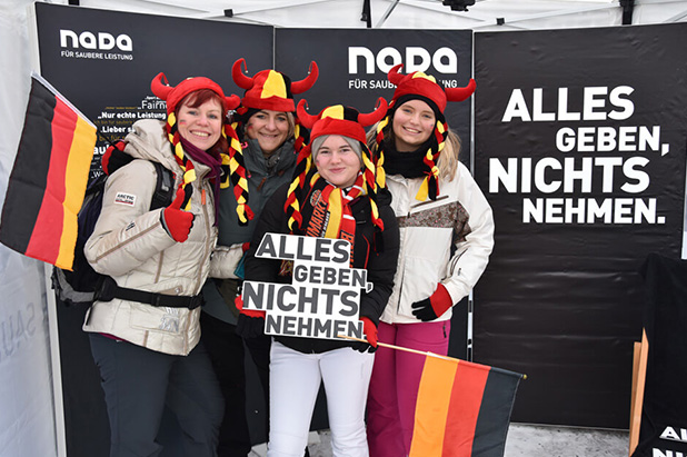 Vier Biathlon-Fans mit Deutschland-Flagge in Foto-Aktion