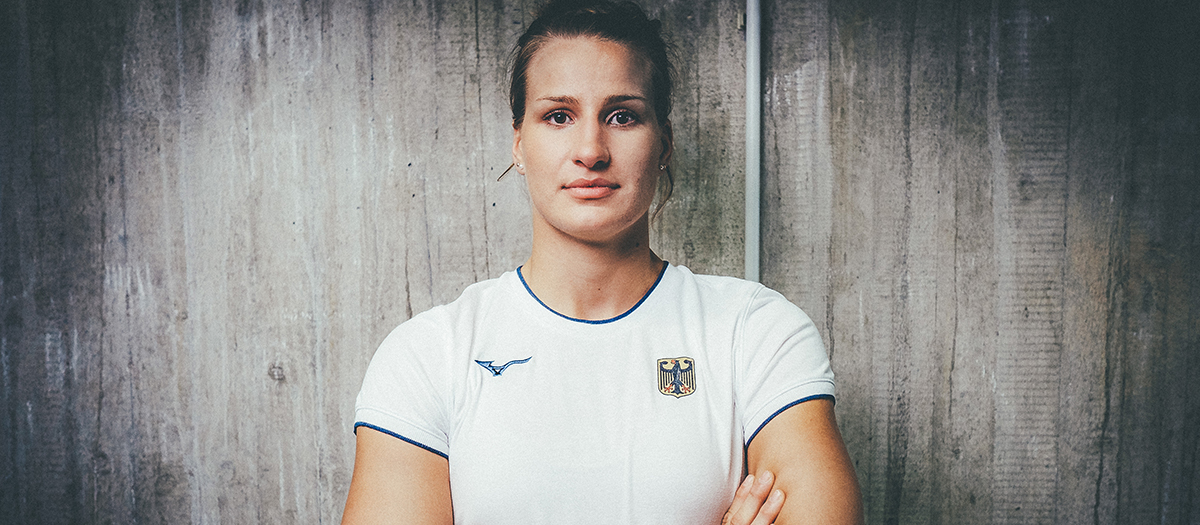 Judoka Anna-Maria Wagner steht mit verschrenkten Armen vor einer Wand