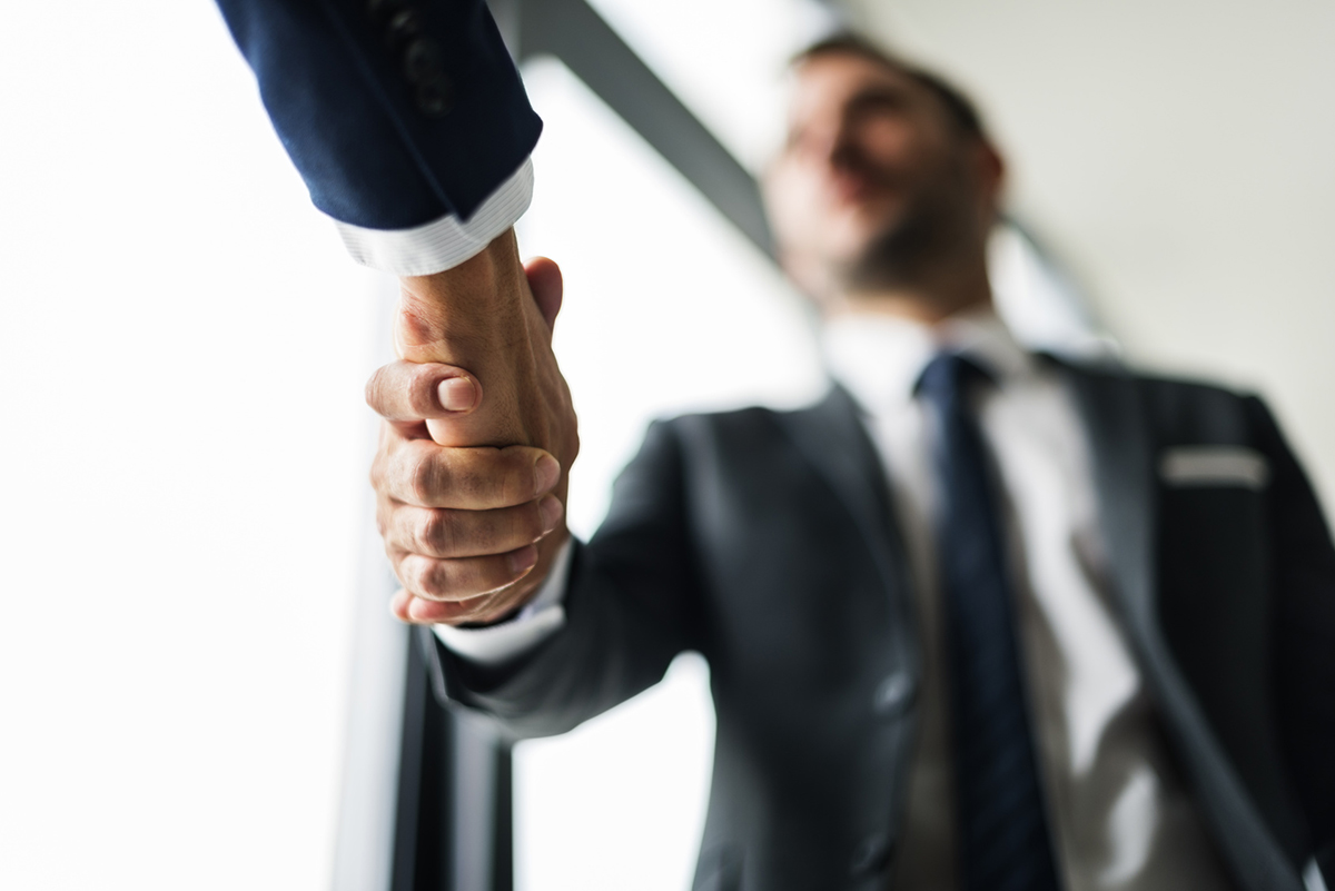 Two people in suits shake hands