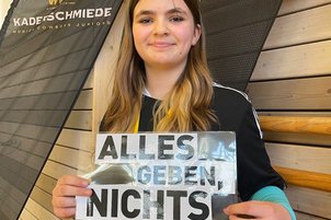 Nachwuchssportler*innen mit Schild in der Hand