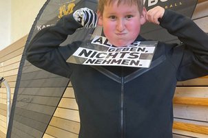 Nachwuchssportler*innen mit Schild in der Hand