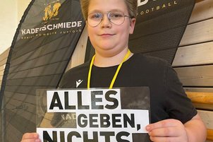 Nachwuchssportler*innen mit Schild in der Hand