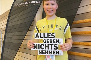 Nachwuchssportler*innen mit Schild in der Hand