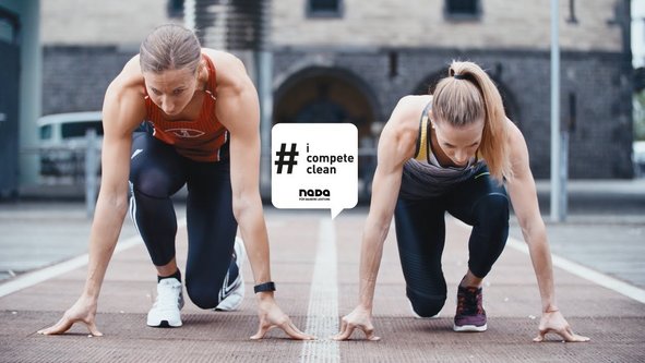 Zwei Frauen in Startposition für einen Lauf auf einer Tartanbahn, darüber eine Sprechblase mit dem Text '# i compete clean' und dem Logo 'nada'