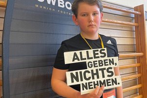 Nachwuchssportler*innen mit Schild in der Hand